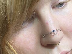 a close up of a person with a nose ring and piercing on it's nose