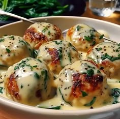 a white bowl filled with cheese covered meatballs