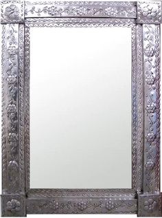 an ornate silver mirror is shown against a white background with the reflection of it's own image