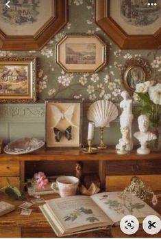 there are many pictures on the wall with flowers and seashells in front of them