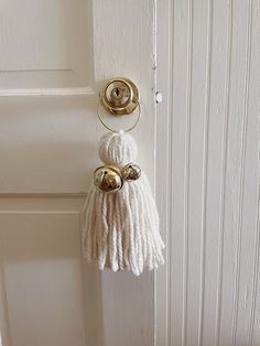 a door handle with a tassel hanging from it's side on a white door