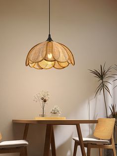 a dining room table with two chairs and a light fixture hanging over it's head