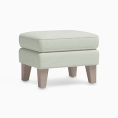 the foot stool is made from wood and has a light green upholstered fabric