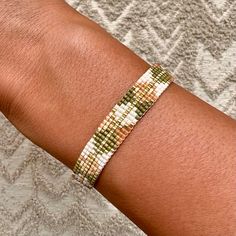 a close up of a person wearing a bracelet on their arm with a diamond pattern