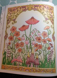 an open coloring book with flowers and mushrooms