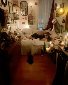 a person laying on a bed in a room with candles and pictures all over the walls