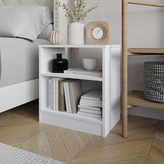 a white shelf with books and vases on top of it in a bedroom next to a bed