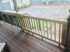 a wooden deck with railings next to a house