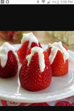 strawberries with whipped cream on them sitting on a plate