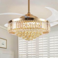 a chandelier hanging from the ceiling in a room with white walls and windows