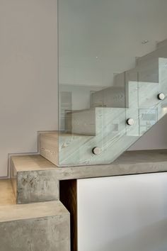 a staircase with glass balustrades and white walls