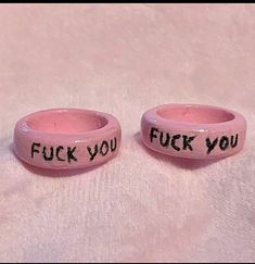 two pink bracelets with words written on them