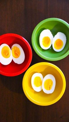 three bowls filled with eggs sitting on top of a wooden table next to each other