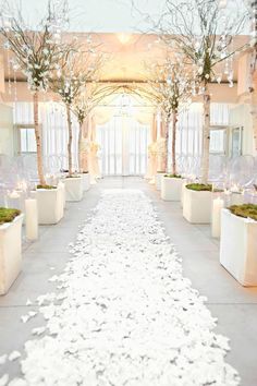 the aisle is decorated with white flowers and candles