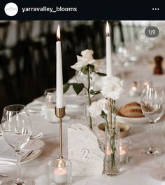 the table is set with white flowers and candles