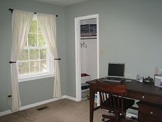 an empty room with a desk and computer