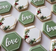 decorated cookies with the words love and roses are arranged on a white tablecloth that says love