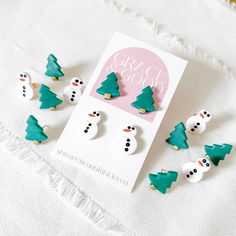 This stud pack contains one pair of lightly sparkly snowman studs with hand-painted accents and one pair of evergreen Christmas tree studs with hand-painted accents. Created using gold-filled finding and nickel free post.  Each earring comes in a secure package with an extra pair of backs to secure your new pretties in to place! GRACE & GOOD styles are delicate, lightweight polymer clay earrings.  They are a beautiful statement piece that is so comfortable, you'll forget you have them on!  GRACE & GOOD earrings are handmade with so much love and it brings me joy to know that they will be worn by someone who truly appreciates them! Treat them well, because although they are durable, they are handmade, unique and hard to replace!  Spread positivity today and every day! Christmas Polymer Clay Earrings, Good Earrings, Christmas Polymer Clay, Evergreen Christmas, Spread Positivity, Earrings Minimalist, Free Post, Delicate Earrings, Modern Earrings