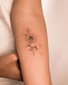 a woman's arm with a sunflower tattoo on the back of her leg