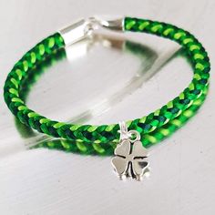 a green and silver bracelet with a shamrock charm