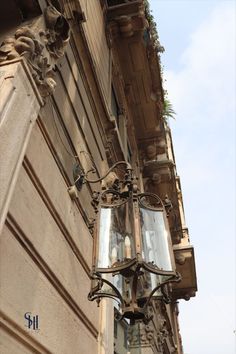 an old fashioned street light hanging from the side of a building