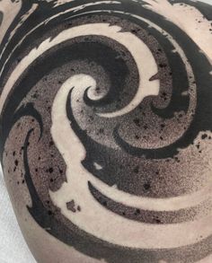 a man's back with black and white swirls on the side of his body