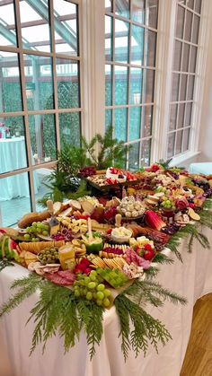 a long table with many different types of food on it in front of a window