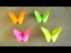 four origami butterflies sitting on top of each other in different colors and sizes