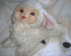 a white stuffed animal laying on top of a bed