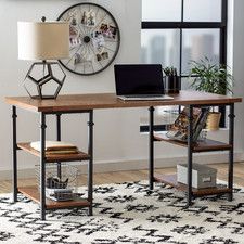 a desk with a laptop on it in front of a wall clock and other items