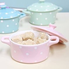 two pink and blue pots with white polka dots on them sitting next to each other