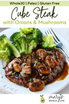 a white plate topped with meat covered in mushrooms and gravy next to broccoli