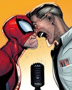 spider - man kissing the face of an older man in front of a microphone with his mouth open