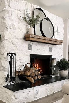 a fireplace with a mirror above it next to a chair and potted plant on the mantle