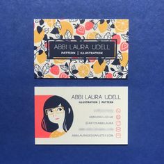 a business card with a woman's face and flowers on the front, sitting on top of a blue surface