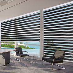 an empty conference room with black chairs and blinds