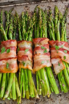 asparagus wrapped in bacon on a baking sheet