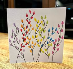 a card with colorful leaves on it sitting on a table