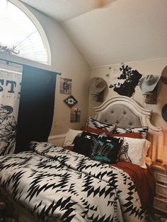 a bed room with a neatly made bed next to a window and pictures on the wall