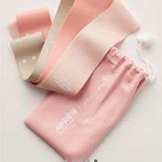 three rolls of pink and white paper on top of each other next to an earbud