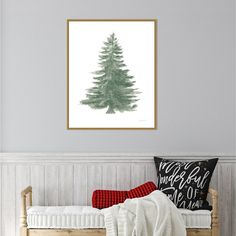 a bedroom with a bed, blanket and framed photograph on the wall above it is a green pine tree