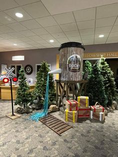 an office decorated for christmas with trees and presents in front of a water tower that says snow worship hall