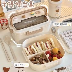 the lunch box is full of food and has utensils in it, along with other items