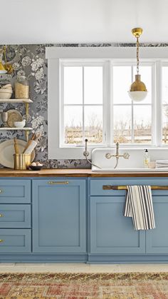 a kitchen with blue cabinets and gold accents on the walls, along with a white sink