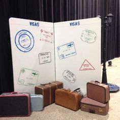 several suitcases are lined up in front of a white board with visa stamps on it