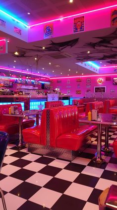 the interior of a diner with checkered flooring and neon lights