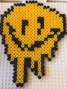 a yellow and black smiley face made out of legos on top of a white surface