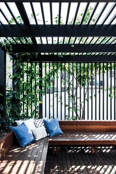 a wooden bench sitting on top of a wooden floor next to a white picket fence