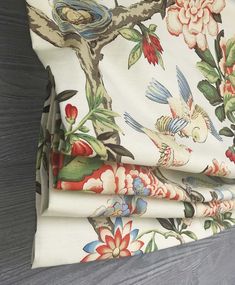 a close up of a flowered curtain with birds and flowers on the outside side