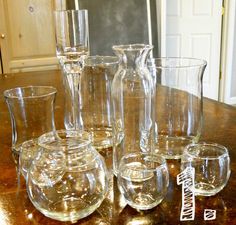 a group of glass vases sitting on top of a wooden table